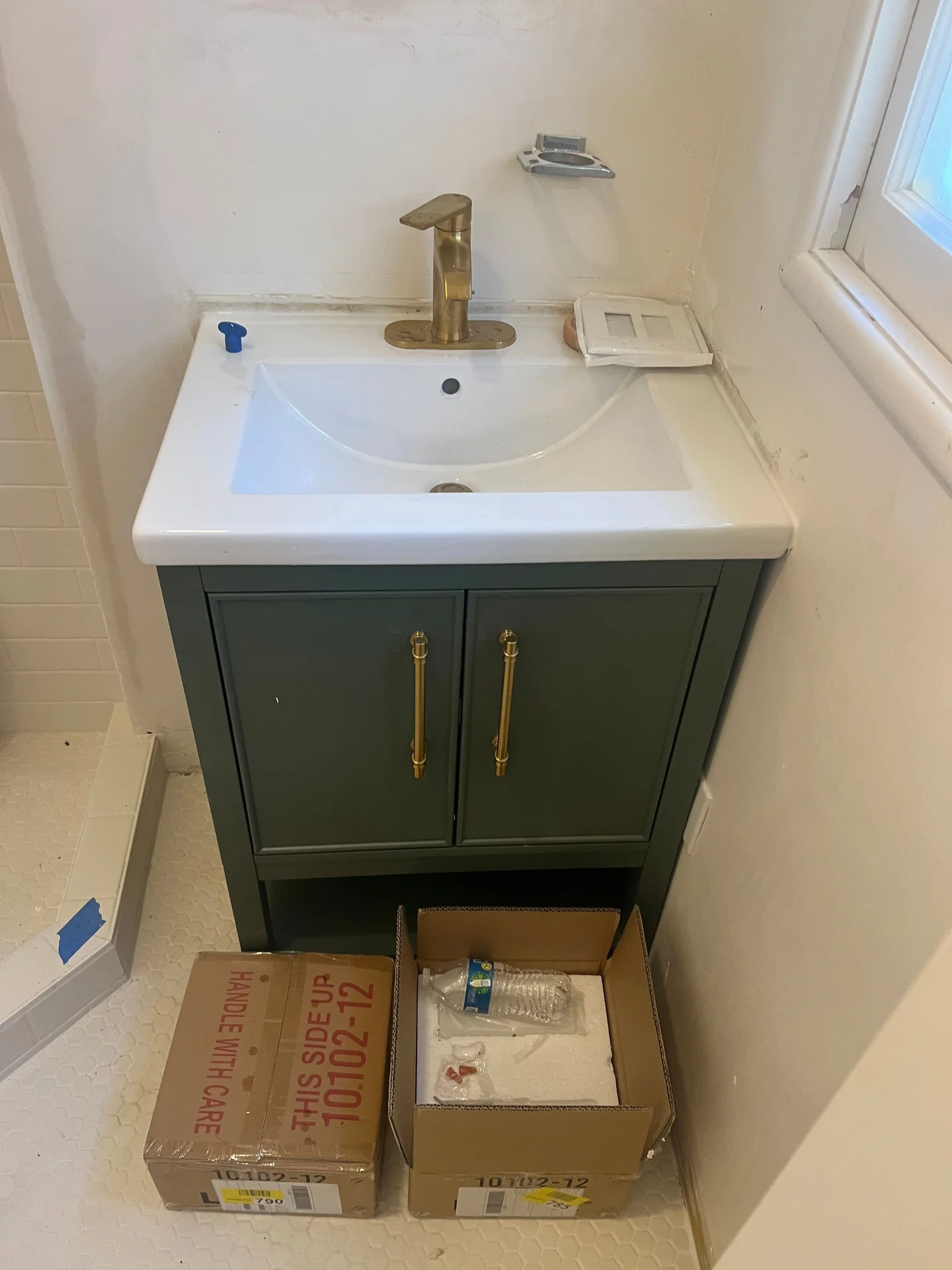 Forest green bathroom vanity with brass hardware, white undermount sink, and matte black faucet