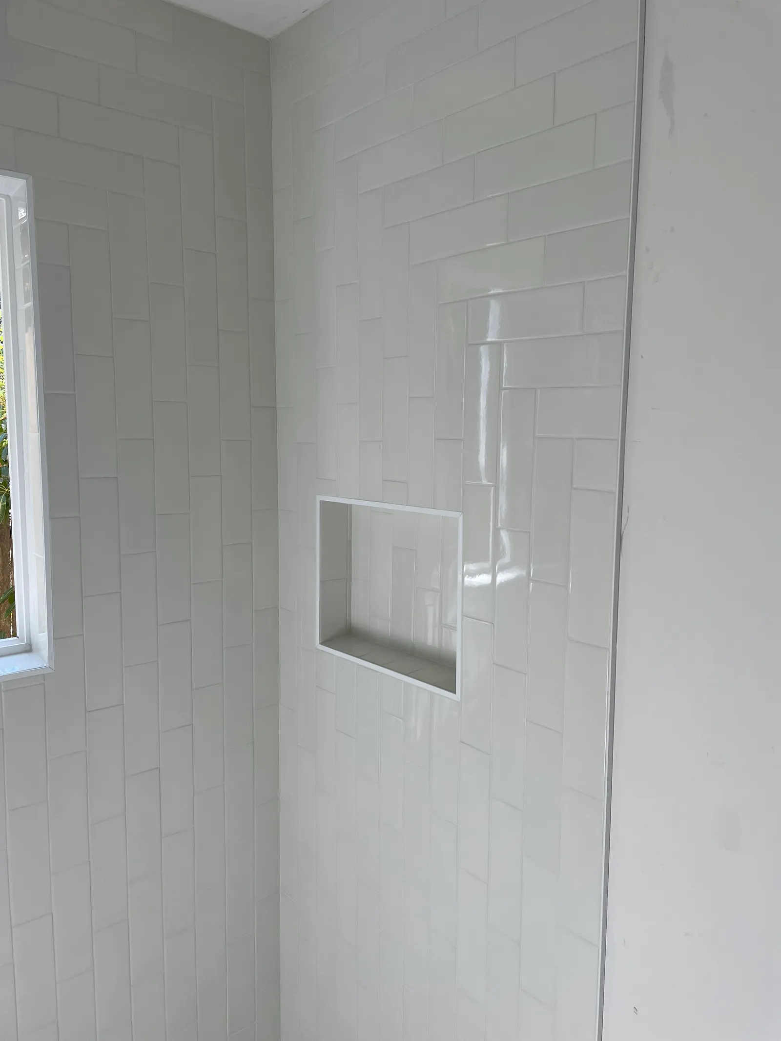 White subway tile shower surround with built-in shampoo niche