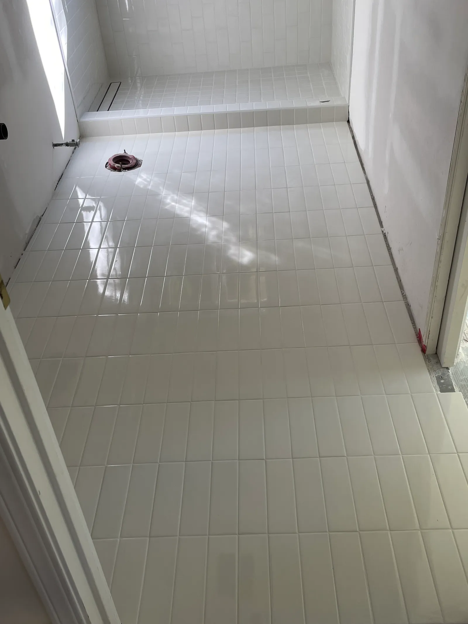 Floor-to-ceiling white subway tile in bathroom with plumbing rough-in