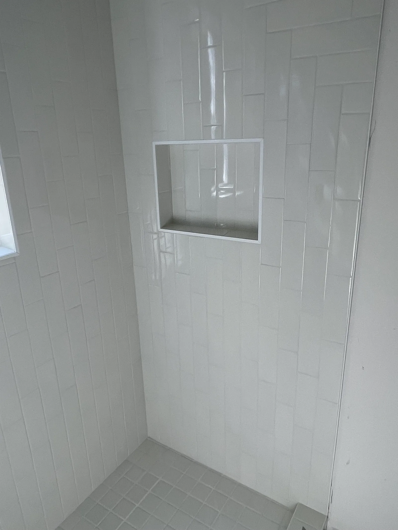 Close-up of subway tile shower niche with clean grout lines