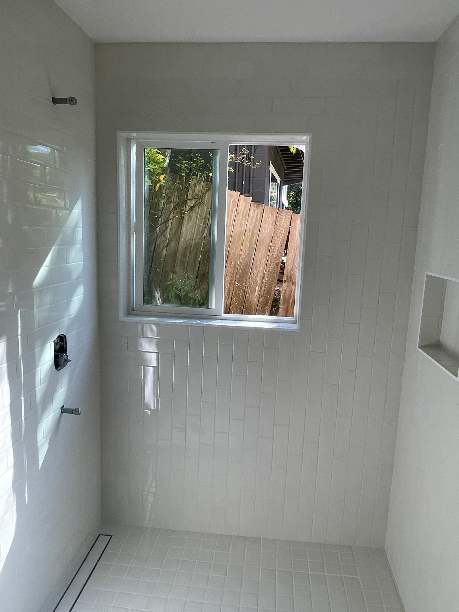 Full bathroom view with white subway tile shower and window