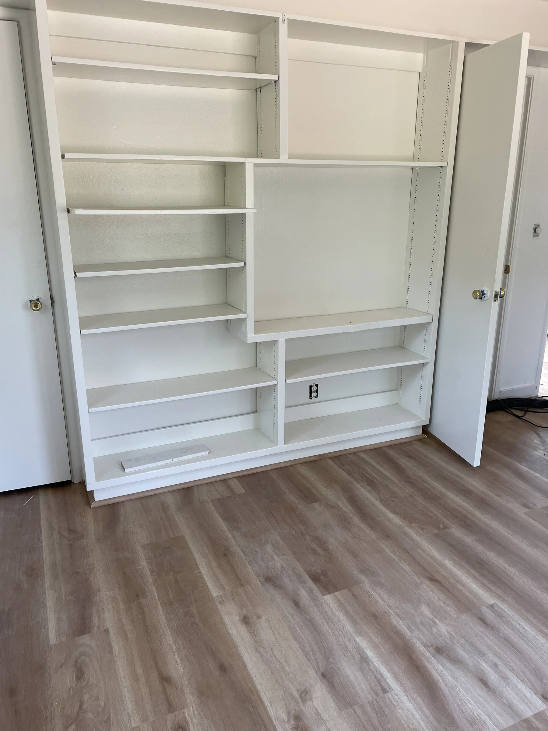 Room in a Montclair Oakland home with gray Impala GAIA LVT wide-plank flooring and custom white built-in shelving