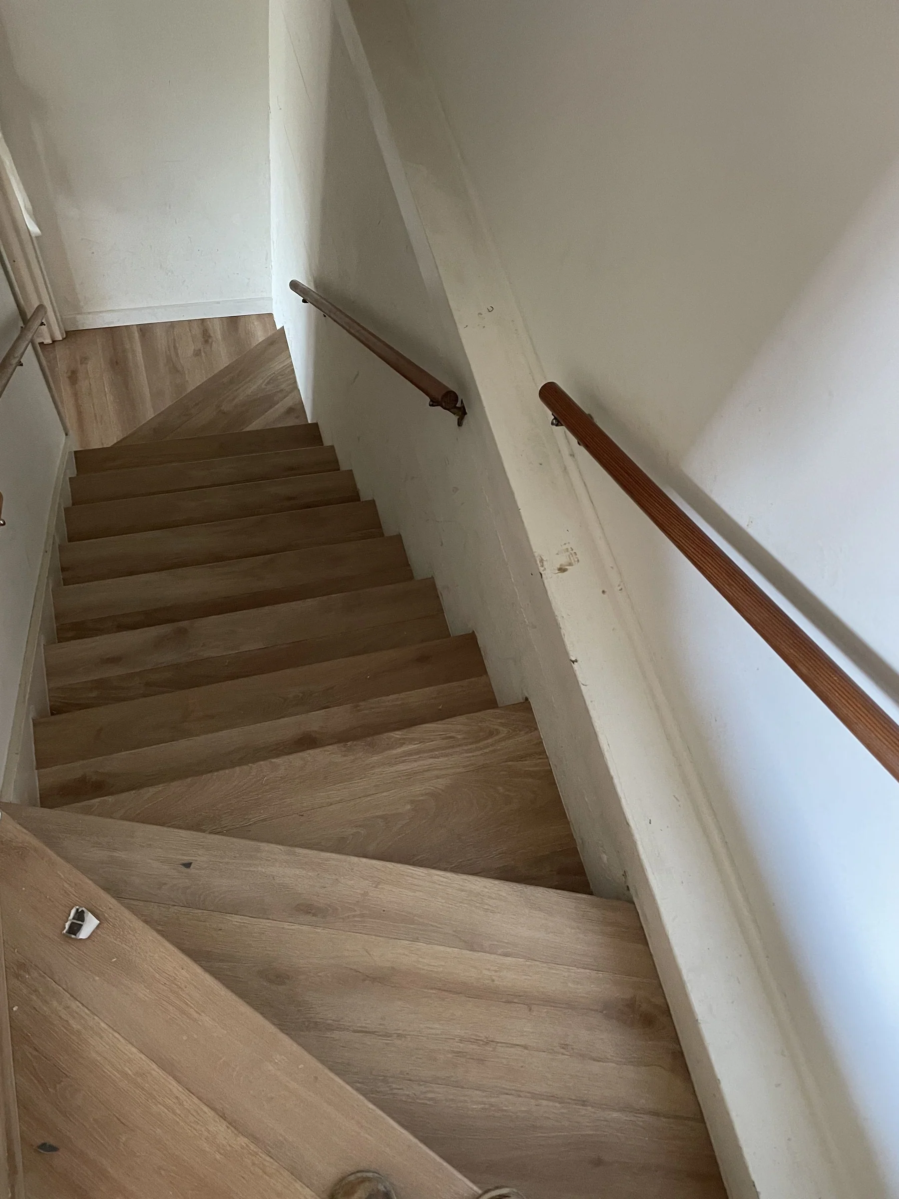 Staircase with Impala GAIA LVT wide-plank flooring in a Montclair Oakland home — treads, risers, and landing