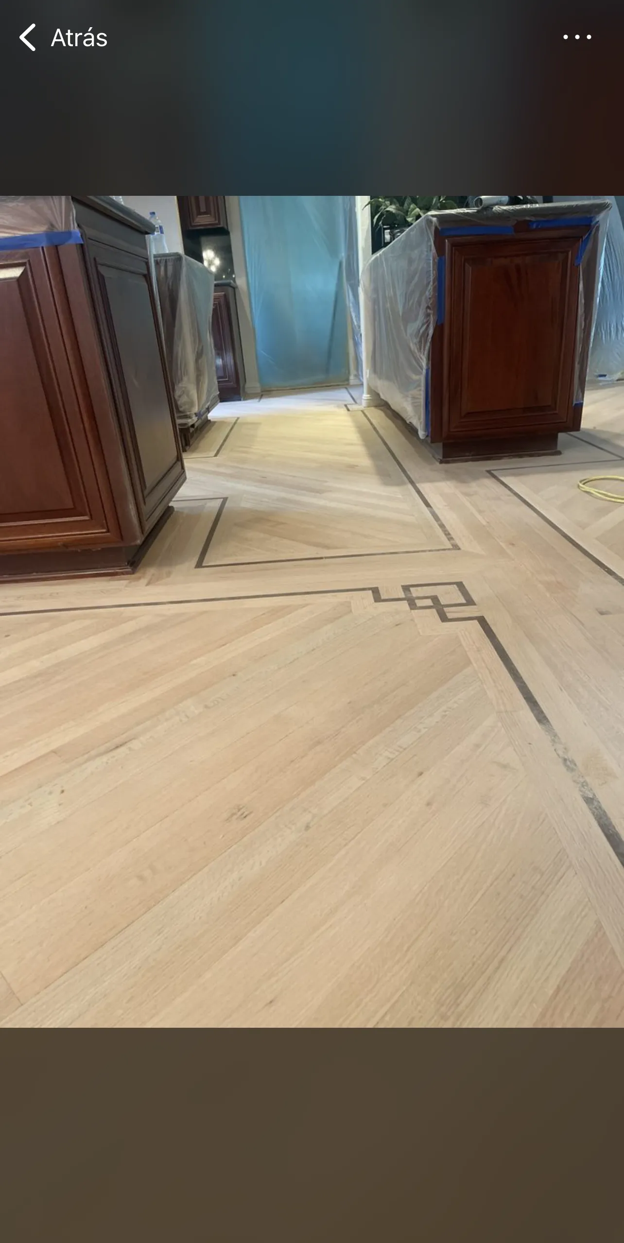 Custom hardwood floor with decorative inlay border in a kitchen
