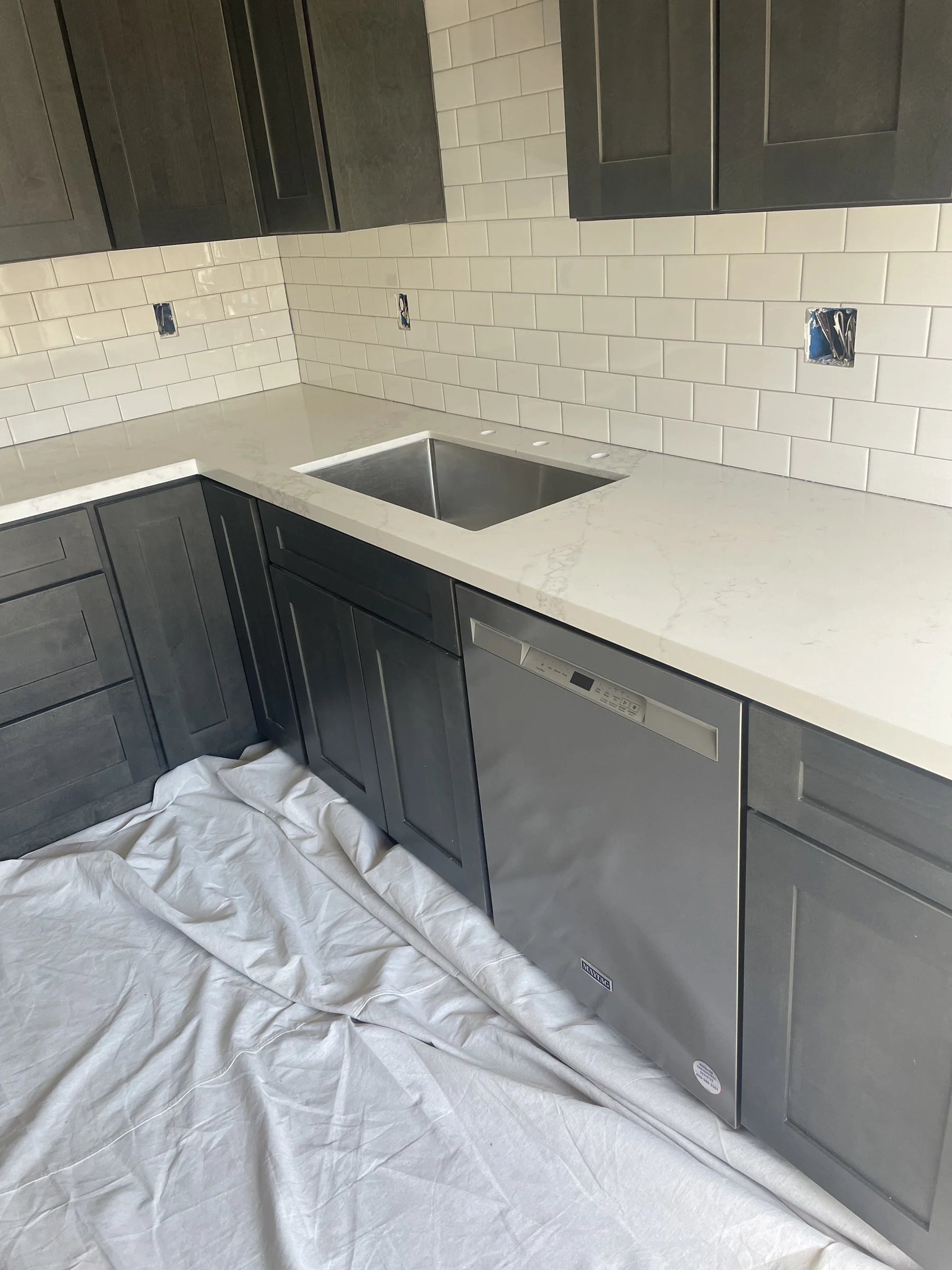 Kitchen remodel in Montclair with dark gray shaker cabinets, white quartz countertop with subtle veining, white subway tile backsplash, and stainless undermount sink