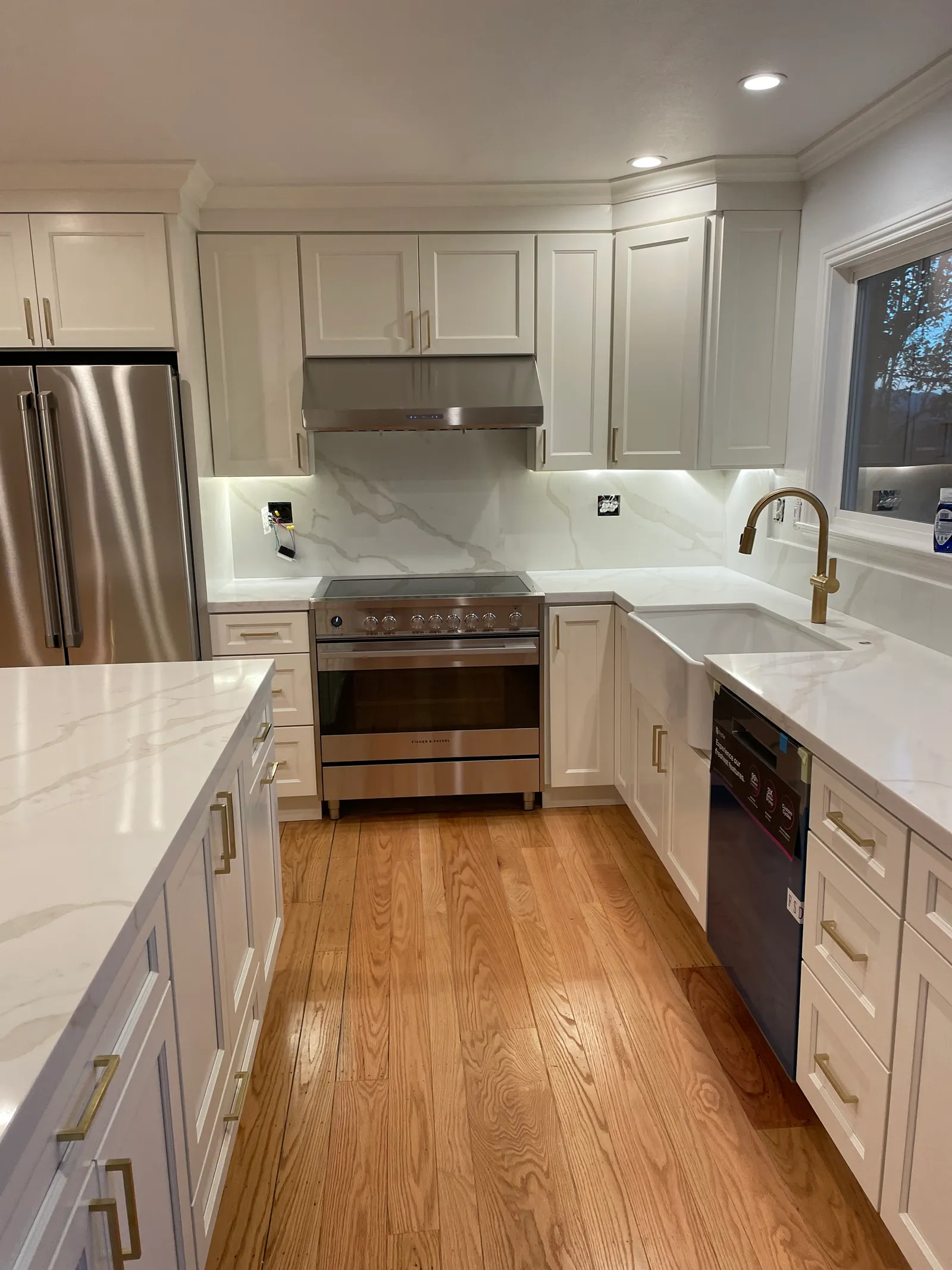 White shaker kitchen island with quartz countertop and hardwood flooring