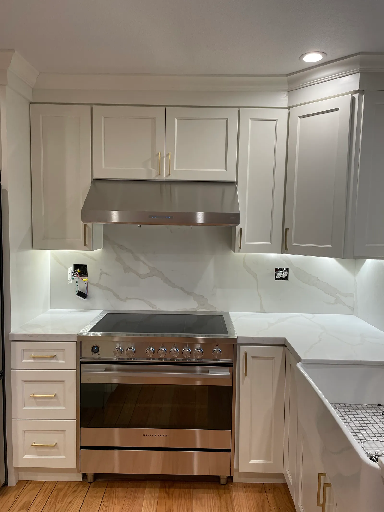 White shaker kitchen with marble-look quartz backsplash and stainless steel range